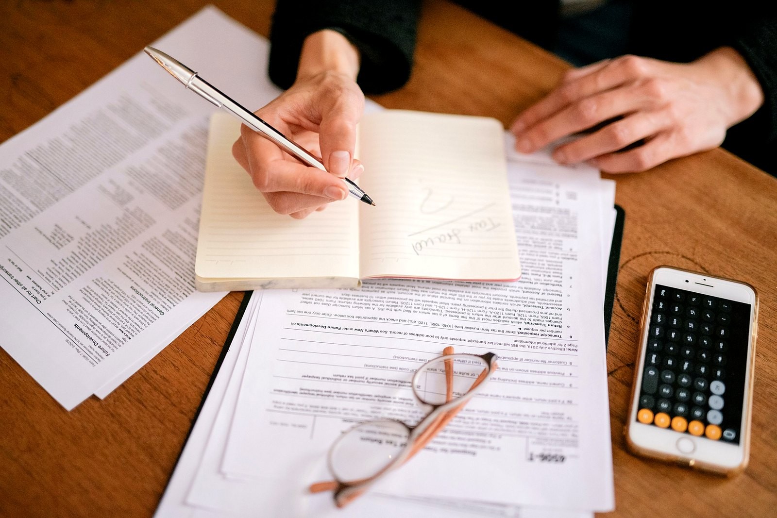 Mãos organizando documentos e planilhas de planejamento financeiro