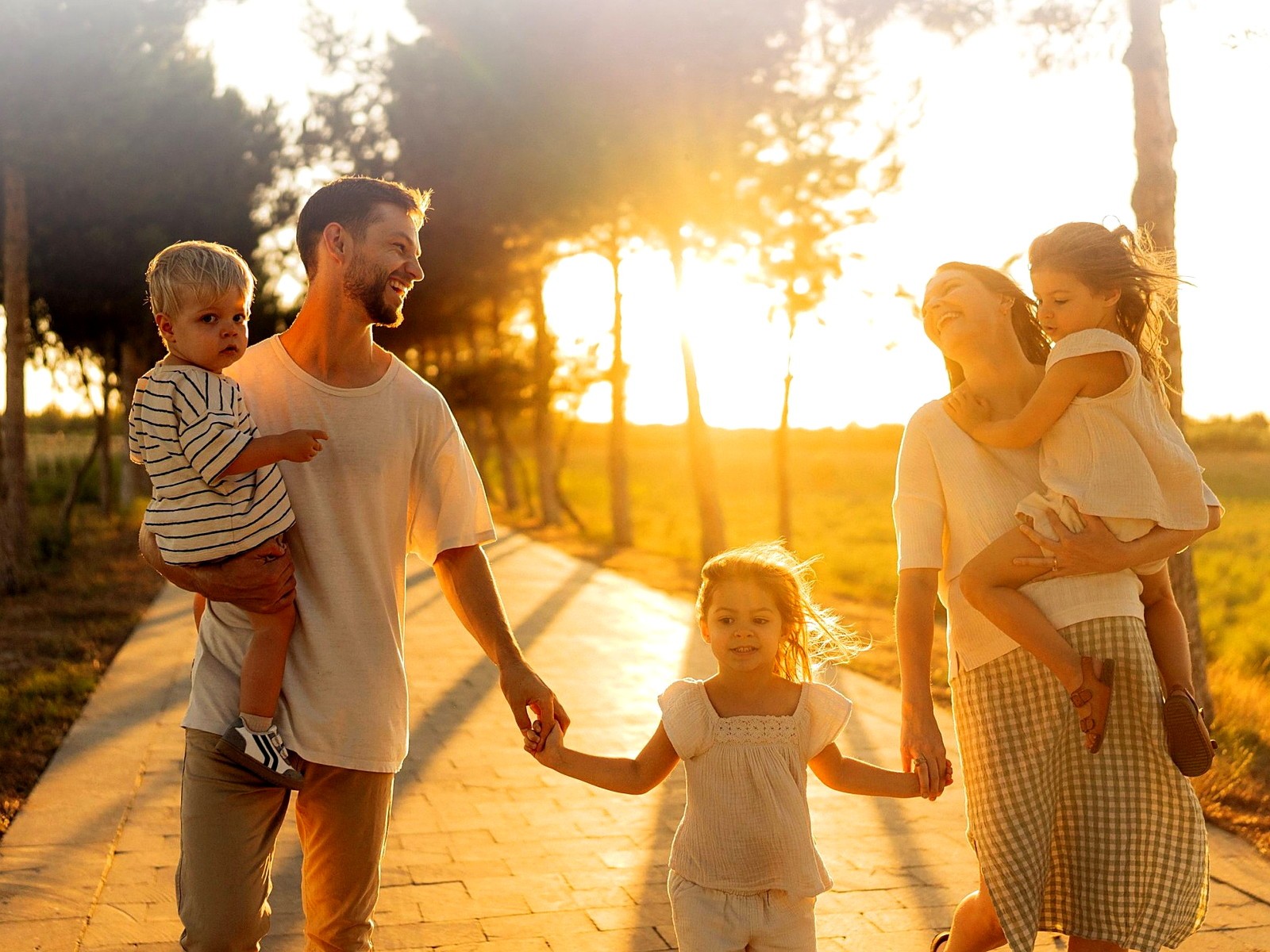 servico-risco Família caminhando junta em um parque ao entardecer