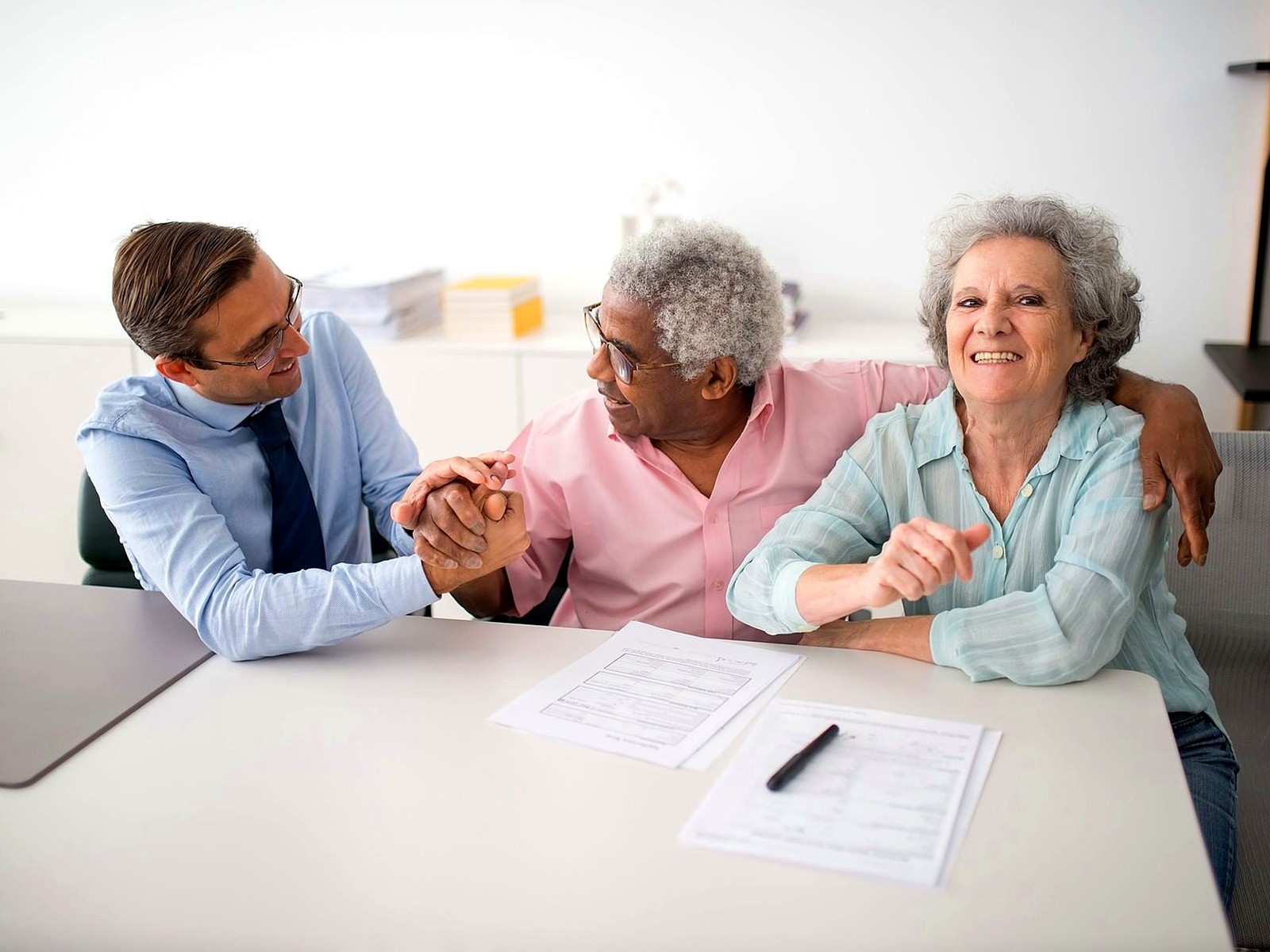servico-sucessorio Assessor conversando com um casal de clientes sobre planejamento sucessório